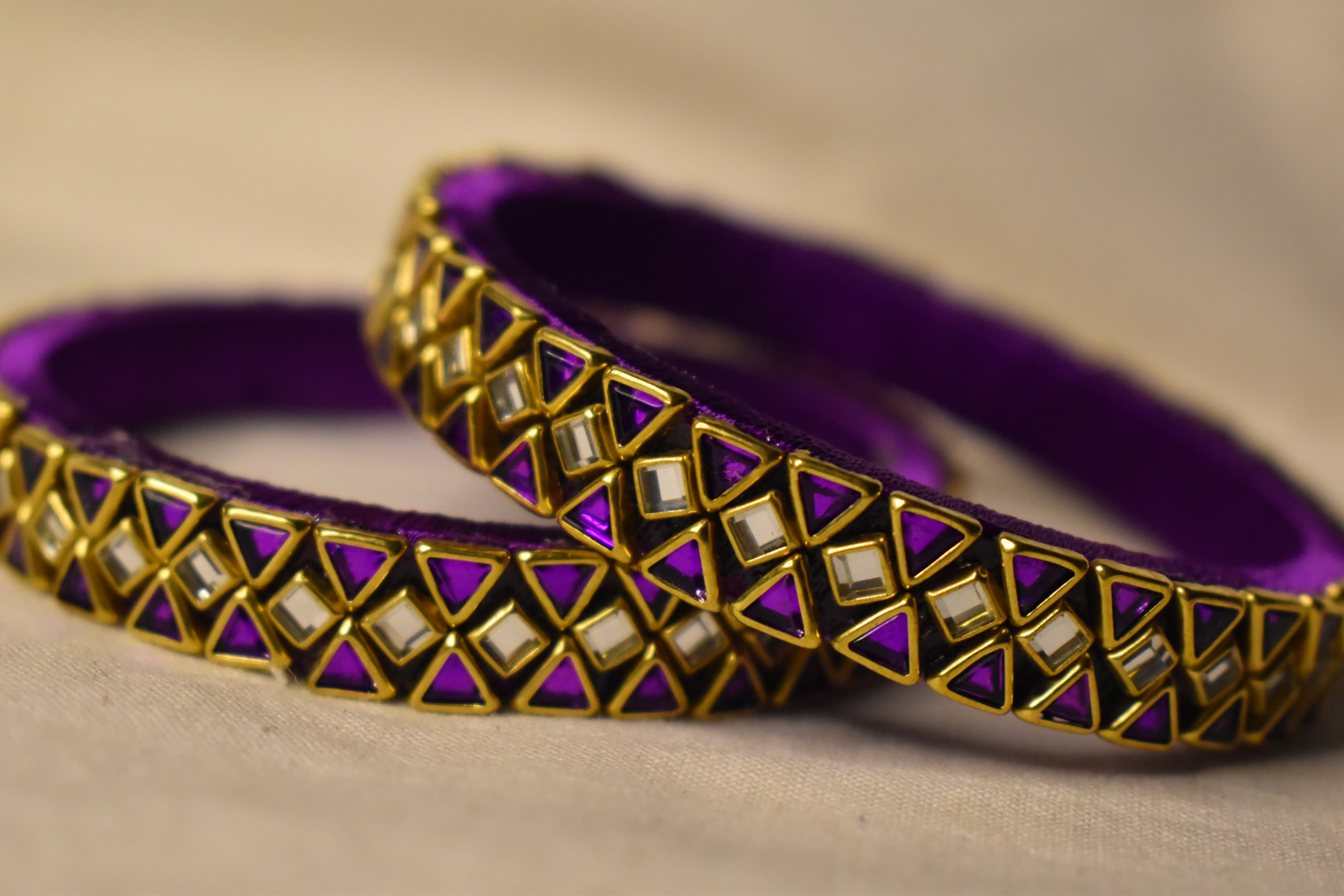 Purple custom geometric bangles with gold mirror-style work by Neevijas